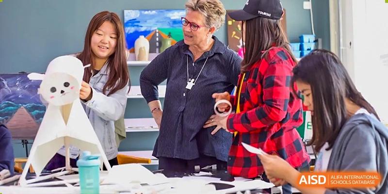 A photo showing a teacher and students having a discussion, at Beijing Zhongguancun Foreign Language School.