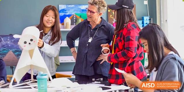 A photo showing a teacher and students having a discussion, at Beijing Zhongguancun Foreign Language School.