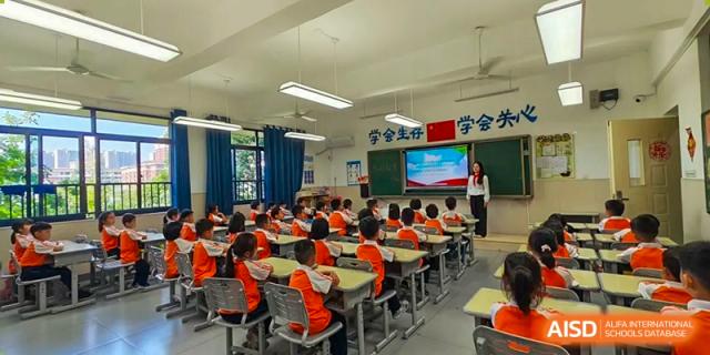 Students of Changsha Lushan Zhongjia School seated in their desks, facing the front of a brightly lit classroom during a lesson.