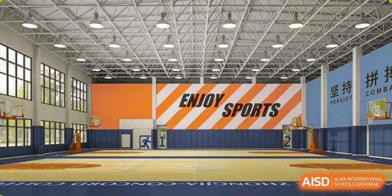 An interior view of the modern, well-lit indoor gymnasium at Changsha Lushan Zhongjia School, featuring orange and white stripes with the large text "ENJOY SPORTS" on the wall.