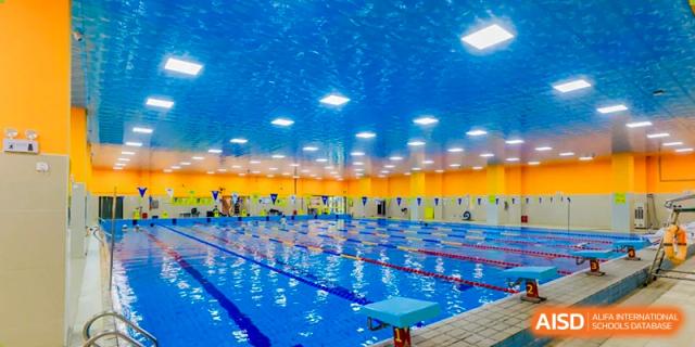 A wide view of the modern, brightly lit indoor swimming pool facility at Changsha Lushan Zhongjia School, showing multiple lanes marked with dividing lines.
