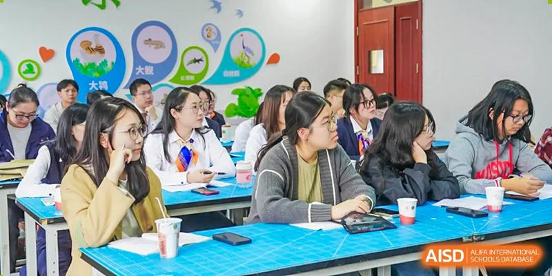 Students sit at desks in a classroom with large windows, engaged in a lesson, at Changshu Lunhua Foreign Language School.