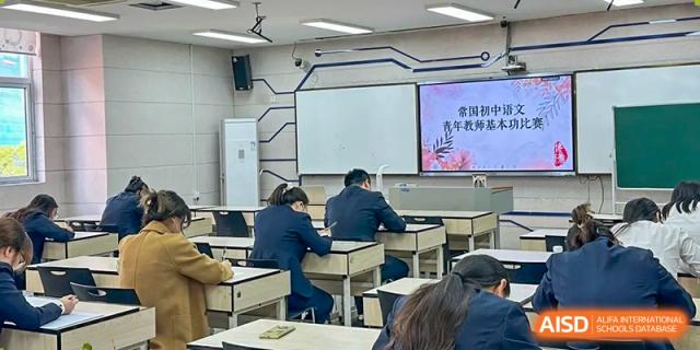 Students sit at desks in a modern classroom with a large digital whiteboard, at Changshu Lunhua Foreign Language School.