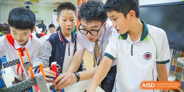 A group of male students in a classroom work on a science project together, at Changshu Lunhua Foreign Language School.
