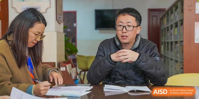 A male teacher speaks to students in a classroom, at Changshu Lunhua Foreign Language School.