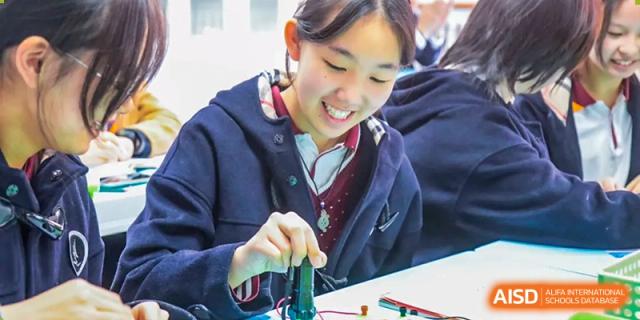 A female student in a classroom conducts a hands-on experiment with a small device, at Changshu Lunhua Foreign Language School.