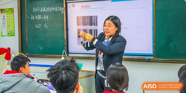 A female teacher gives a science demonstration to students in a classroom, at Changshu Lunhua Foreign Language School.