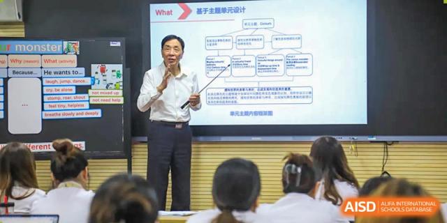A male teacher gives a presentation to students in a classroom, at Changshu Lunhua Foreign Language School.