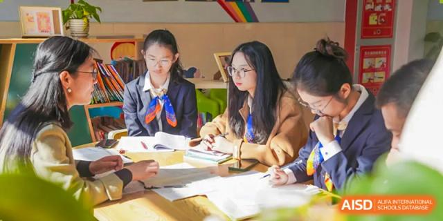 Two female students study together at a desk, at Changshu Lunhua Foreign Language School.