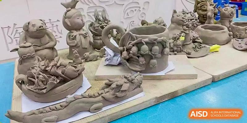 Students' clay sculptures are displayed outdoors, at Changshu Lunhua Foreign Language School.