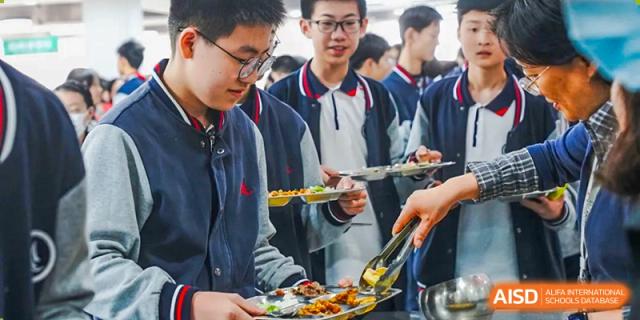 Students queue up to get food from a buffet line, at Changshu Lunhua Foreign Language School.