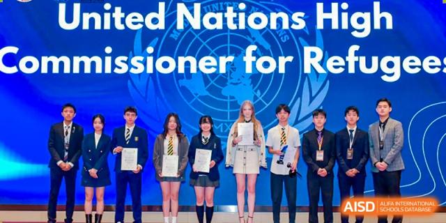 A group of students from Chiway Bilingual School Xiamen posing together on a stage beneath a banner for a United Nations event.