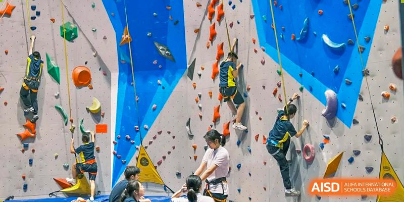 Students at Chiway Bilingual School Xiamen participating in a supervised rock climbing activity on an indoor wall.
