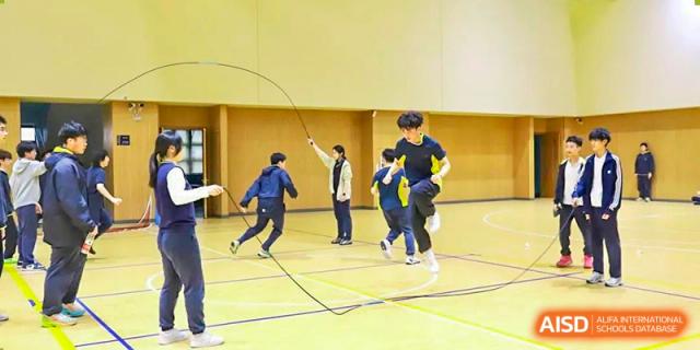 Students at Chiway Bilingual School Xiamen participating in jump rope activities in an indoor gymnasium.