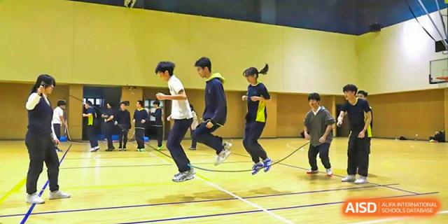 Students at Chiway Bilingual School Xiamen running and jumping rope together during a physical education class.