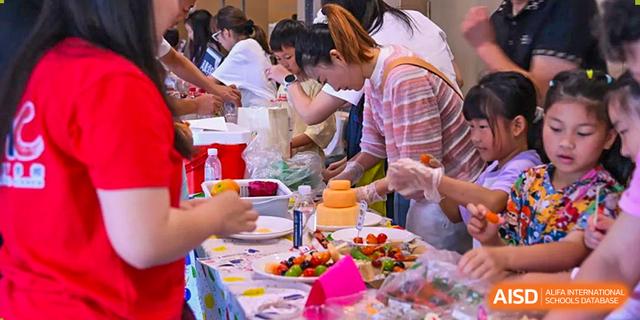 Students and adults from Chiway Bilingual School Xiamen participating in a fun cooking or food preparation activity, decorating treats.