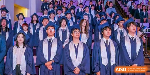 Students from Dipont Huayao Collegiate School Kunshan are posing in their graduation caps and gowns.