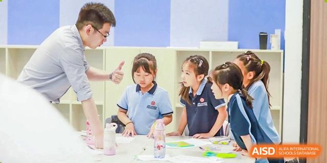 Younger students from Dipont Huayao Collegiate School Kunshan are seated at a table, participating in a group activity.