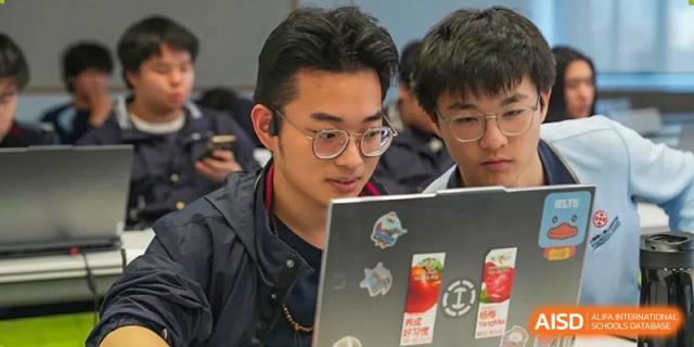 A male student from Dipont Huayao Collegiate School Kunshan is focused on his laptop during a class.