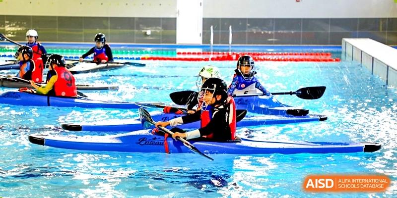 Students from Dipont Huayao Collegiate School Kunshan are participating in a kayaking activity in a swimming pool.