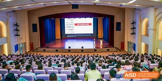 Students and parents from Dipont Huayao Collegiate School Kunshan attend a presentation in a large auditorium.