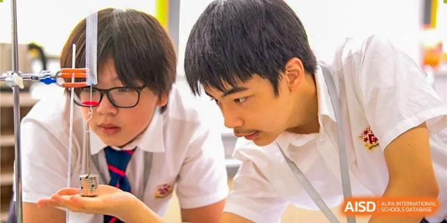 Students from Dulwich College Beijing are looking at something with focus in a classroom.