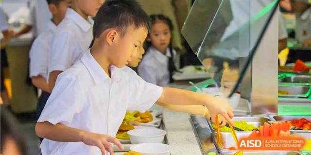 A student serving himself food in the cafeteria line at Dulwich College Beijing.