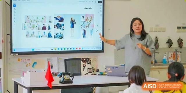 A teacher at Harrow International School Shanghai helping students with a project in a classroom.