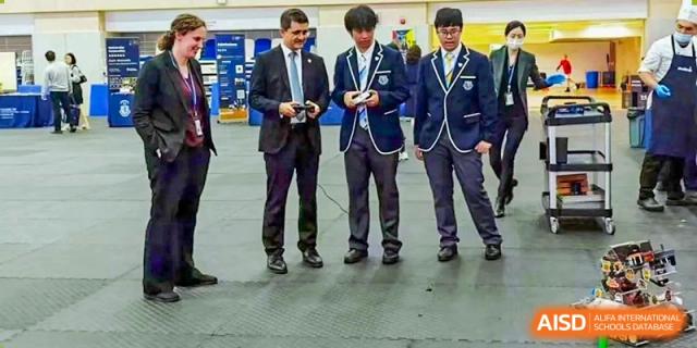Students from Harrow International School Shanghai holding controllers for a robotics project.