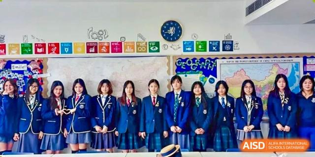 A group of students from Harrow International School Shanghai standing together for a photo in a classroom.