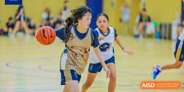 Two female students from Harrow International School Shanghai playing a basketball game.