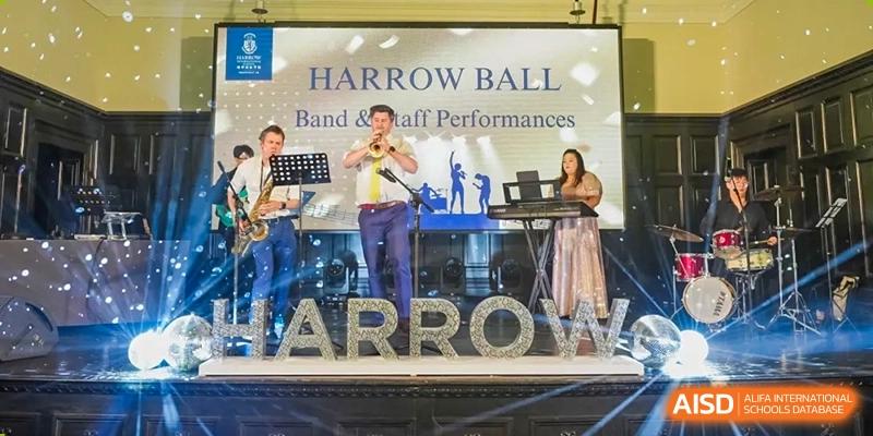A male student from Harrow International School Shanghai playing a violin on stage with 'Harrow Ball' in the background.