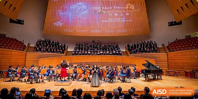 Students and faculty from Harrow International School Shanghai performing in an orchestra on a large stage.