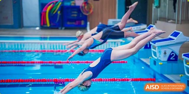 A student from Harrow International School Shanghai diving into a swimming pool.