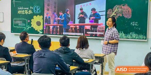 Students seated in a classroom watching a presentation or performance projected on a large screen at The No.2 High School Of East China Normal University (HSEFZ).