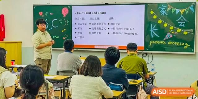 A classroom lesson in progress, with a teacher's content on "Unit 5 Out and about" projected on a screen for students at The No.2 High School Of East China Normal University (HSEFZ).