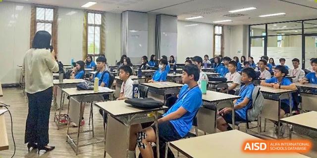 Students seated in a bright classroom, with one student in a blue shirt visible in the foreground at The No.2 High School Of East China Normal University (HSEFZ).