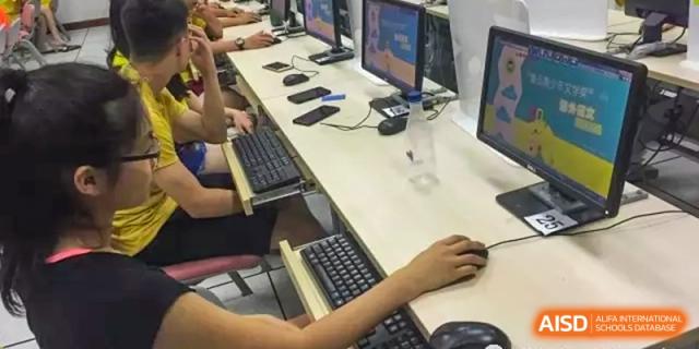 A close-up of a student's hands on a keyboard and mouse at a computer station at The No.2 High School Of East China Normal University (HSEFZ).