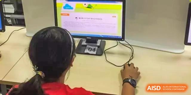 A student using a computer mouse to interact with a digital learning task displayed on a monitor at The No.2 High School Of East China Normal University (HSEFZ).