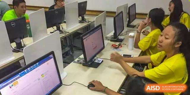 A student working on a desktop computer in a computer lab or classroom at The No.2 High School Of East China Normal University (HSEFZ).