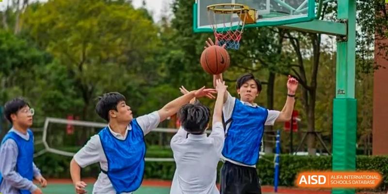 Three students jumping upThree students jumping up to grab a basketball during an intense play in an outdoor game at TheNo.2 High School Of East China Normal University (HSEFZ).