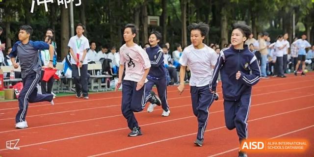 Two male students running on the track during a distance race or warm-up at The No.2 High School Of East China Normal University (HSEFZ).