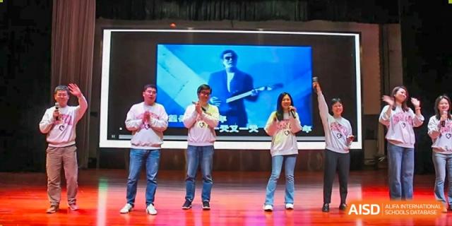 Three students singing or performing on stage in casual clothes during a school event at The No.2 High School Of East China Normal University (HSEFZ).