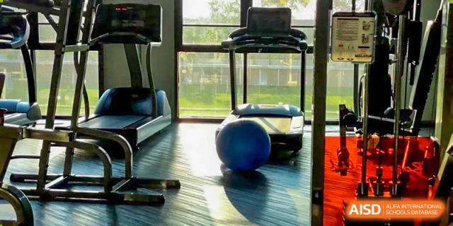 A treadmill and blue exercise ball inside a brightly lit fitness room or gymnasium at The No.2 High School Of East China Normal University (HSEFZ).
