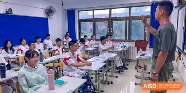 Students are seated at desks in a classroom, with a teacher at the front, at the International Curriculum Center of RDFZ.