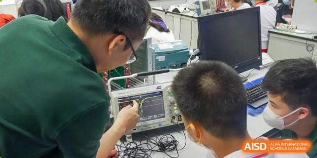 Two students in a lab are working on an experiment with electronic equipment at the International Curriculum Center of RDFZ.