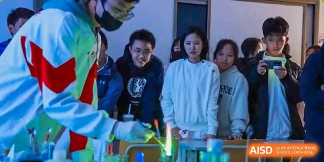 A group of students are gathered around a table, looking at something on the table at the International Curriculum Center of RDFZ.