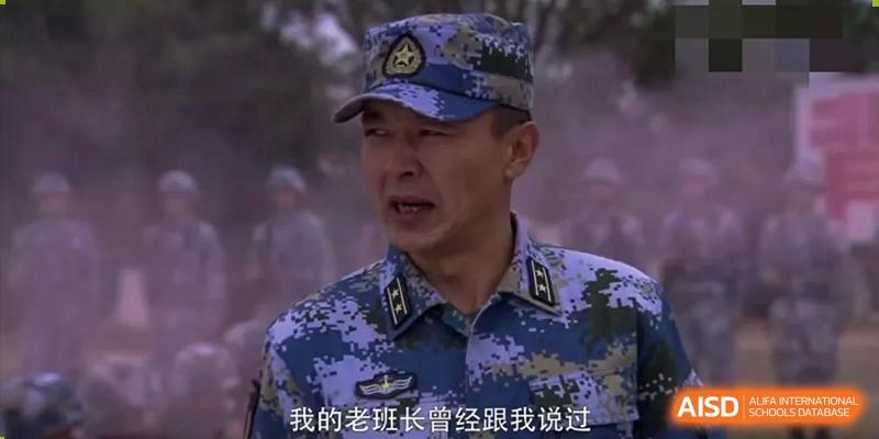 A man in a military-style camouflage uniform is speaking, with Chinese characters visible at the bottom of the image, at the International Curriculum Center of RDFZ.