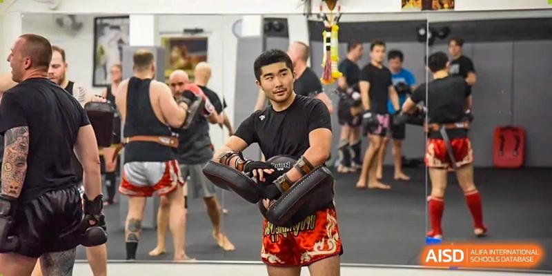 Two people are practicing a martial art, with one person holding a pad while the other is wearing boxing gloves, at the International Curriculum Center of RDFZ.