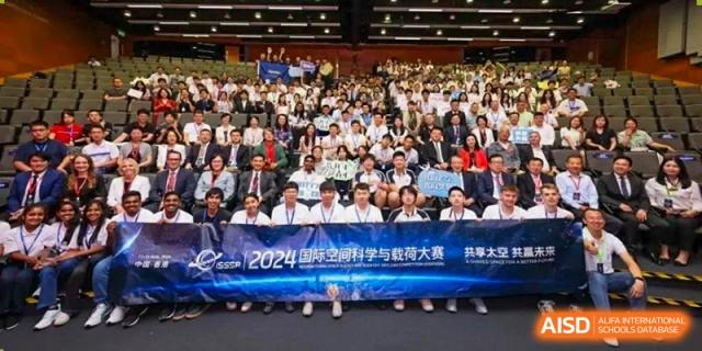 A large group of students and faculty are posing for a group photo in front of a banner that reads "2024 International Curriculum Center of RDFZ."